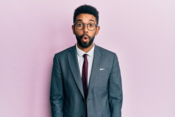 Handsome hispanic business man with beard wearing business suit and tie afraid and shocked with surprise expression, fear and excited face.