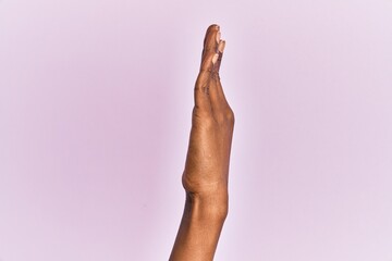 Arm and hand of black middle age woman over pink isolated background showing side of stretched...