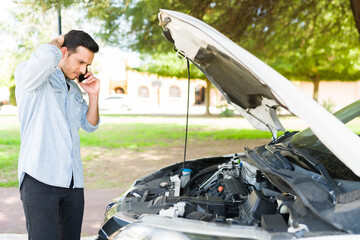 Good-looking guy trying to fix his broken down car