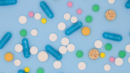 A lot of colorful medical pills, capsules on blue background with copy space. Background from multi-colored medical capsules, tablets. Medical layout. background
