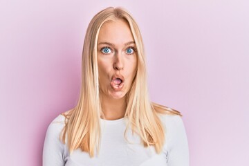 Young blonde girl wearing casual clothes afraid and shocked with surprise expression, fear and excited face.