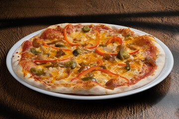 Spicy pizza on a thin dough with bell pepper, jalapeno pepper, onion and cheese