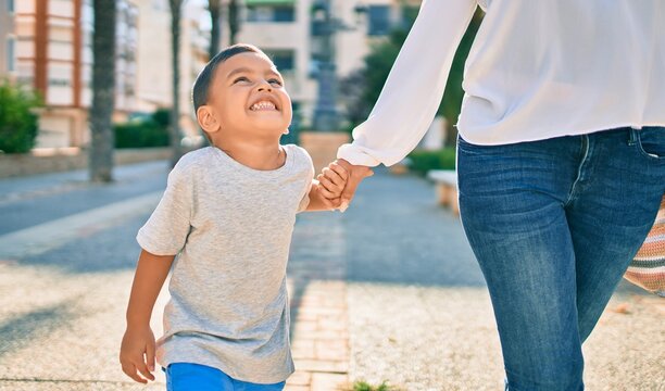 Adorable latin mother and son walking at the city.