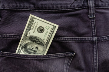 One hundred American Dollars Banknote in a jeans pocket on rotating table. Extreme close-up, Shallow Depth of Field. Business