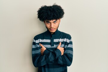 Obraz premium Young african american man with afro hair wearing casual clothes skeptic and nervous, disapproving expression on face with crossed arms. negative person.