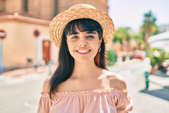 Young hispanic tourist girl wearing summer style walking at the city.