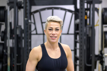 Obraz premium Attractive fit sporty blond woman posing in a gym