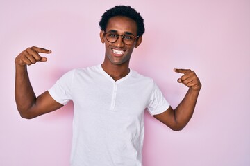 African handsome man wearing casual clothes and glasses looking confident with smile on face,...