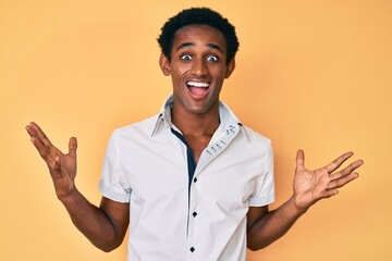 African handsome man wearing casual shirt celebrating victory with happy smile and winner expression with raised hands