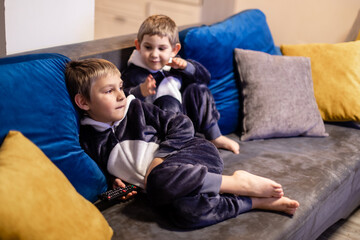 the little brothers in kigurumi watching tv at home