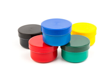 Plastic jars with paint of different colors for children's creativity on white background. Paint...