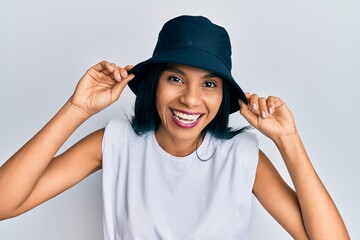 Young african american woman wearing fashion hat smiling and laughing hard out loud because funny crazy joke.