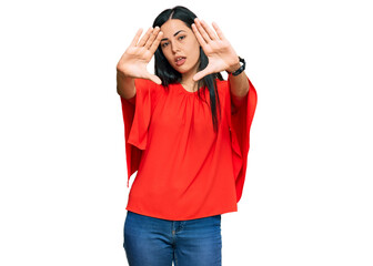 Beautiful young woman wearing casual clothes doing frame using hands palms and fingers, camera perspective