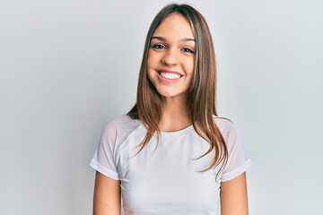 Young brunette woman wearing casual white t shirt with a happy and cool smile on face. lucky person. - obrazy, fototapety, plakaty