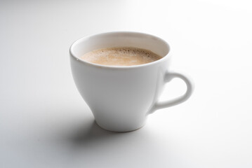 White cup of coffee in soft light isolated on a white background. Cappuccino coffee. 