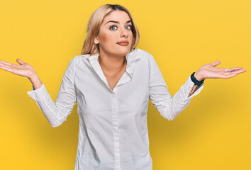 Young caucasian woman wearing casual clothes clueless and confused expression with arms and hands raised. doubt concept.