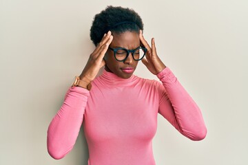 Young african american girl wearing casual clothes and glasses with hand on head, headache because stress. suffering migraine.