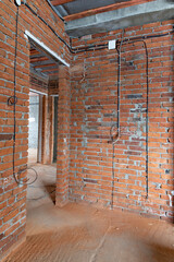 home improvement, electric cables are stretched in the new room on a brick wall without people