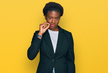 Young african american girl wearing business clothes mouth and lips shut as zip with fingers....