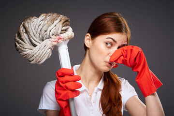 cleaning lady covers her nose with her fingers unpleasant smell mop in hand cleaning discontent