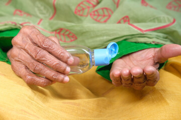 close up of senior women hand using sanitizer gel for preventing virus 