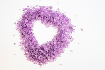 Heart-shaped lavender body salt on a white background. Body treatment, skin care concept. Flat lay.