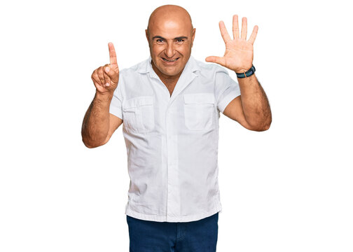 Mature middle east man with mustache wearing casual white shirt showing and pointing up with fingers number six while smiling confident and happy.