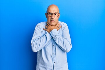 Middle age bald man wearing casual clothes and glasses shouting and suffocate because painful strangle. health problem. asphyxiate and suicide concept.