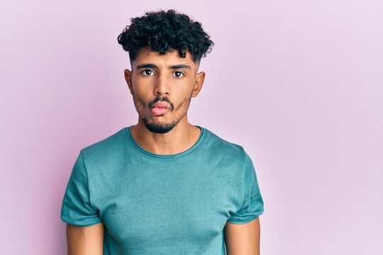 Young arab handsome man wearing casual clothes making fish face with lips, crazy and comical gesture. funny expression.