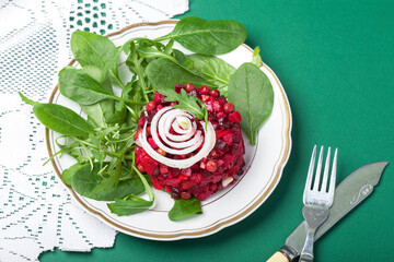 Vinaigrette. Traditional russian beetroot salad with boiled vegetables, pickled cucumbers, sour cabbage, olive oil and green canned peas. Vegetarian healthy dinner. White wooden background. Close up.