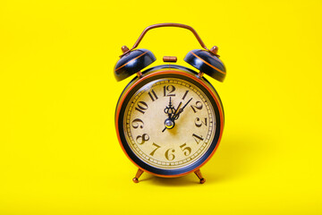 Alarm clock on a yellow background, bright and sunny.