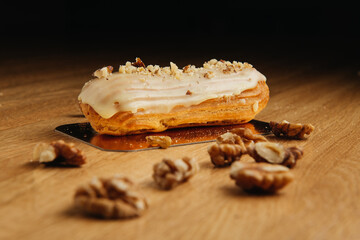 Eclair with glaze on wooden table