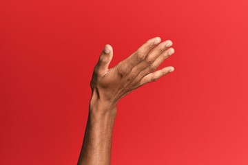 Hand of hispanic man over red isolated background presenting with open palm, reaching for support and help, assistance gesture