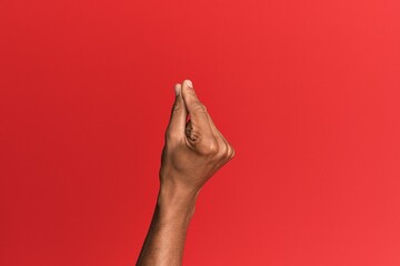 Hand of hispanic man over red isolated background holding blank space with thumb finger, business...