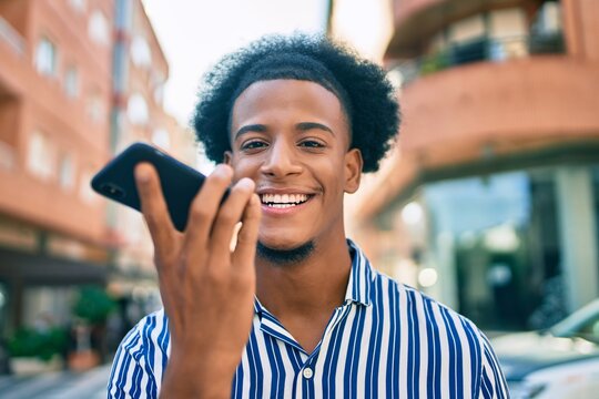 Young african american man smiling happy sending audio message using smartphone at the city.