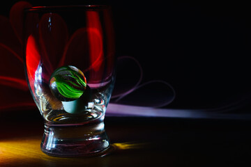 green marbles in a drinking water glass 