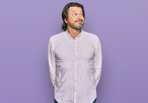 Middle age handsome man wearing business shirt smiling looking to the side and staring away thinking.