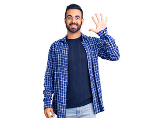 Young hispanic man wearing casual clothes showing and pointing up with fingers number five while...
