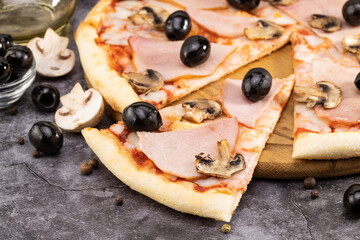 slice of pizza and pizza ingredients. Olives, mushrooms and pizza on a dark background