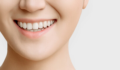 smile of a woman with beautiful white teeth close-up on a white background copy space.the concept of smooth healthy teeth
