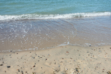 Soft wave with white foam, sea surf on sandy beach. Travel concept, sea vacation