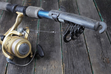Fishing spinning rod on wooden background, close-up, selective focus