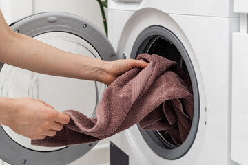 Woman washing laundry using modern automatic machine