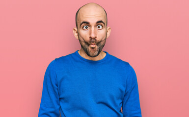 Young hispanic man wearing casual clothes making fish face with lips, crazy and comical gesture. funny expression.