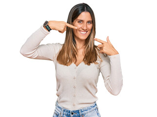 Obraz na płótnie Canvas Young woman wearing casual clothes smiling cheerful showing and pointing with fingers teeth and mouth. dental health concept.