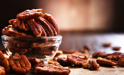 Composition with a bowl of shelled pecan nuts. Delicacies