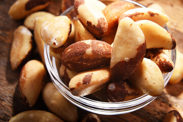 Composition with a bowl of shelled brazil nuts. Delicacies