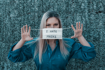 Young beautiful woman rejecting putting on her face mask during COVID19