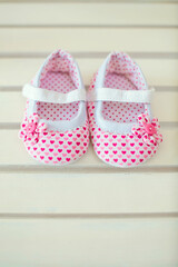 Fototapeta na wymiar Baby shoes for newborns on white wooden background