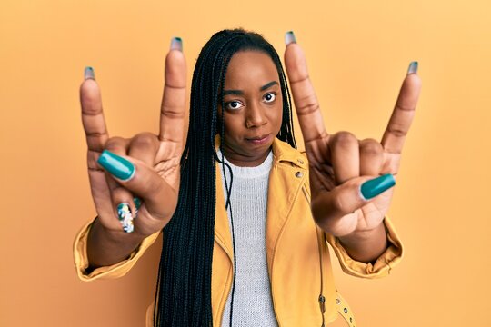 Young african american woman doing rock gesture skeptic and nervous, frowning upset because of problem. negative person.